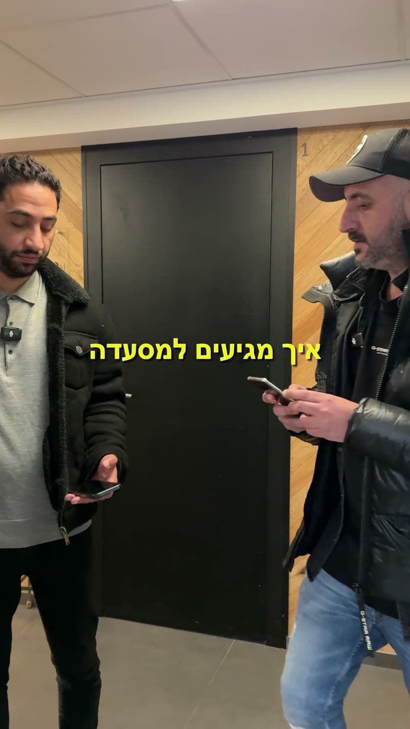 פריים מהסרטון: שני אנשים על מרפסת משרד עם טלפונים